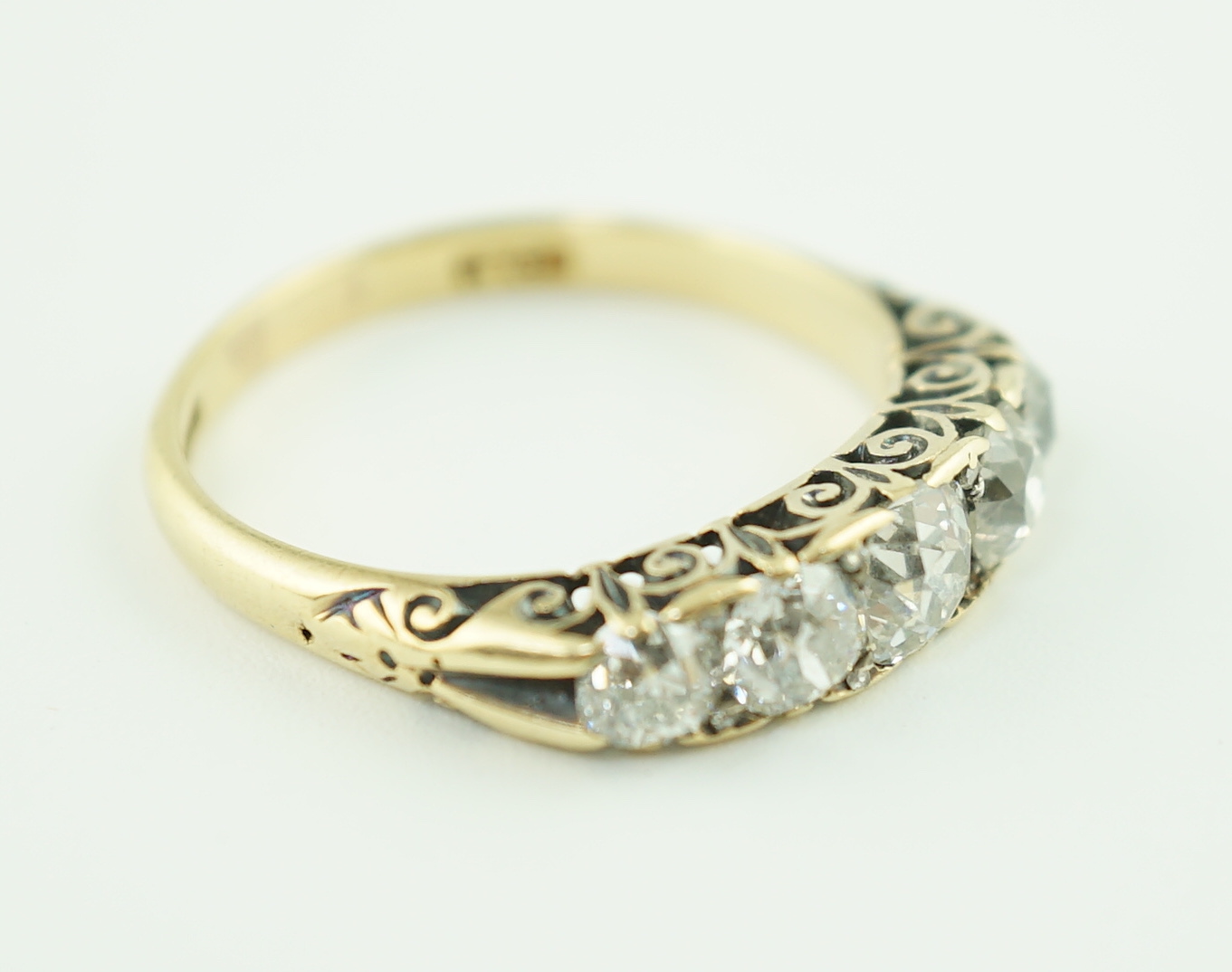 An early 20th century 18ct gold and graduated five stone old cut diamond set half hoop ring